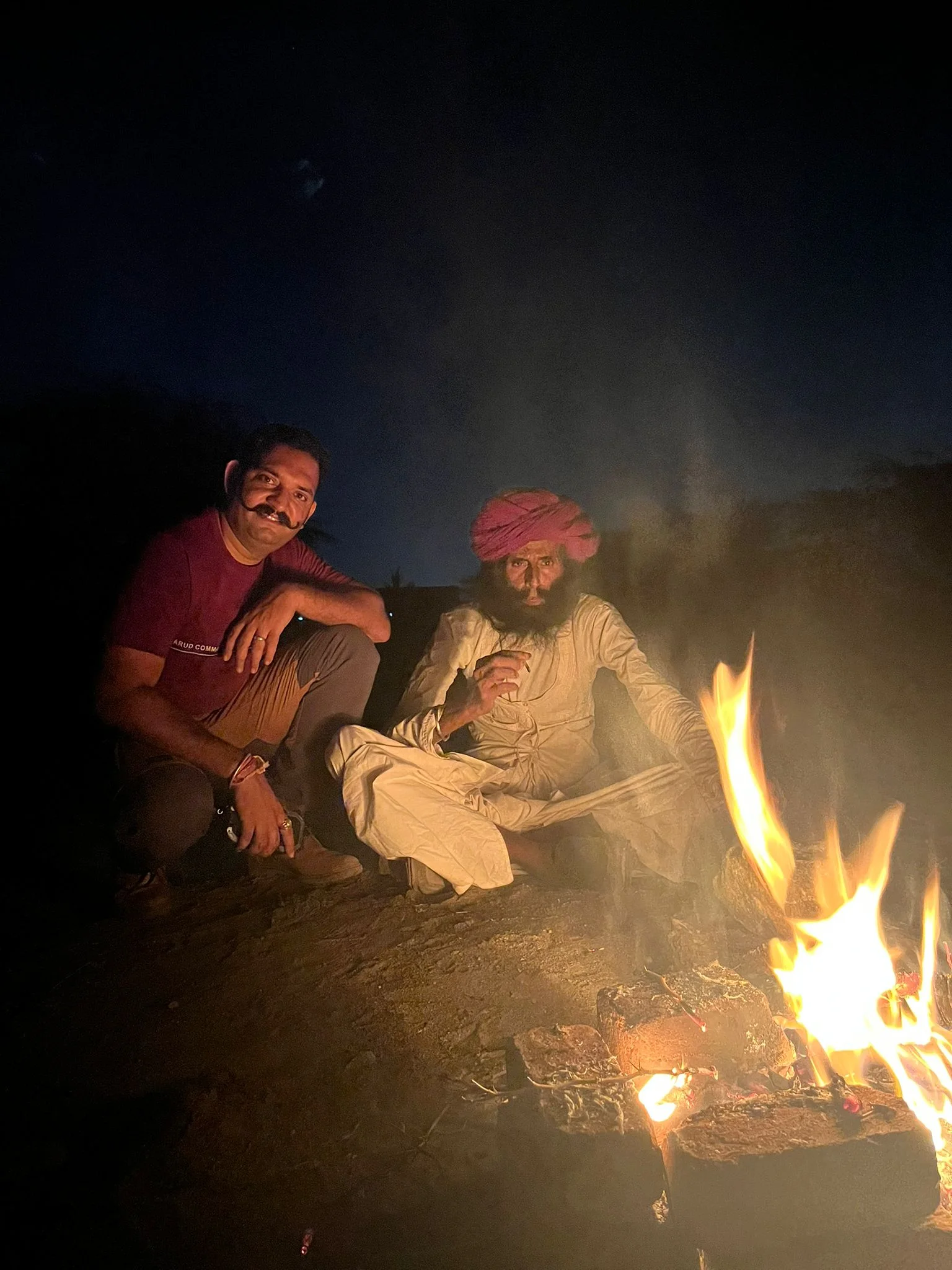 Abhi partage un moment autour du feu avec un homme rebari au Rajasthan