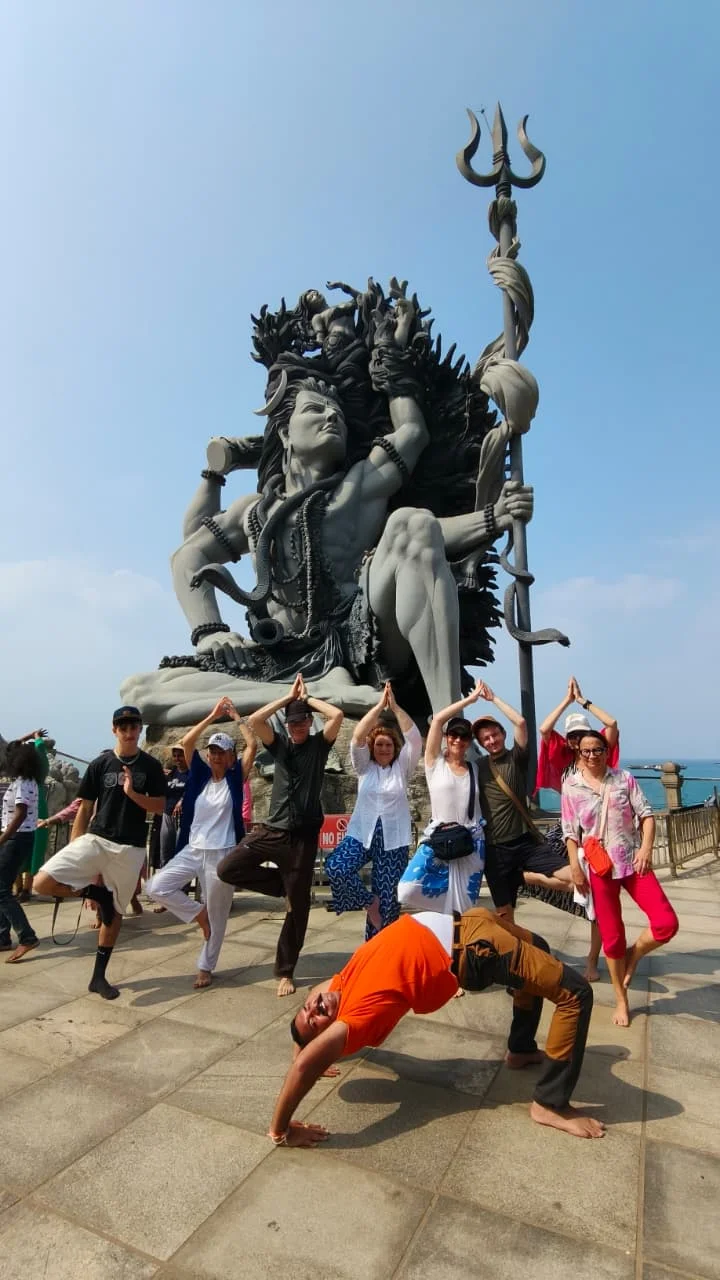 Moment de yoga avec Abhimanyu et un petit groupe devant une statue de Shiva