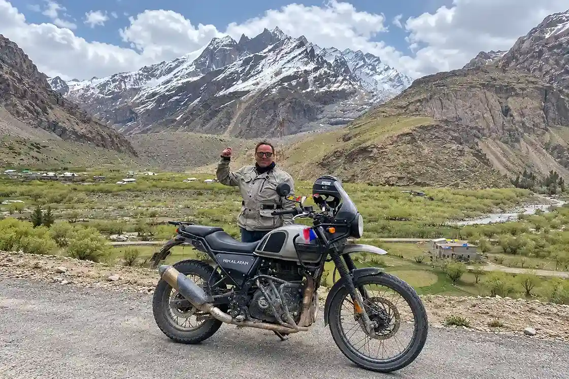 Voyageur avec sa Royal Enfield Himalayan devant les montagnes de l’Himalaya