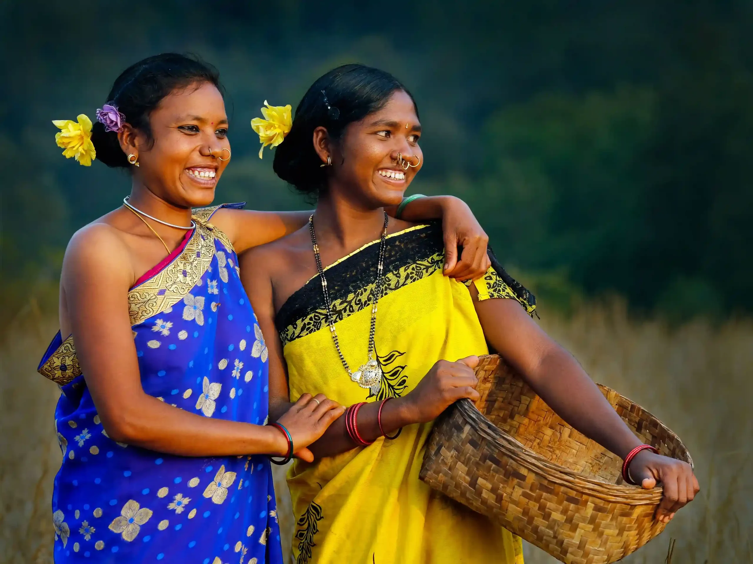 Deux femmes souriantes en saris bleu et jaune